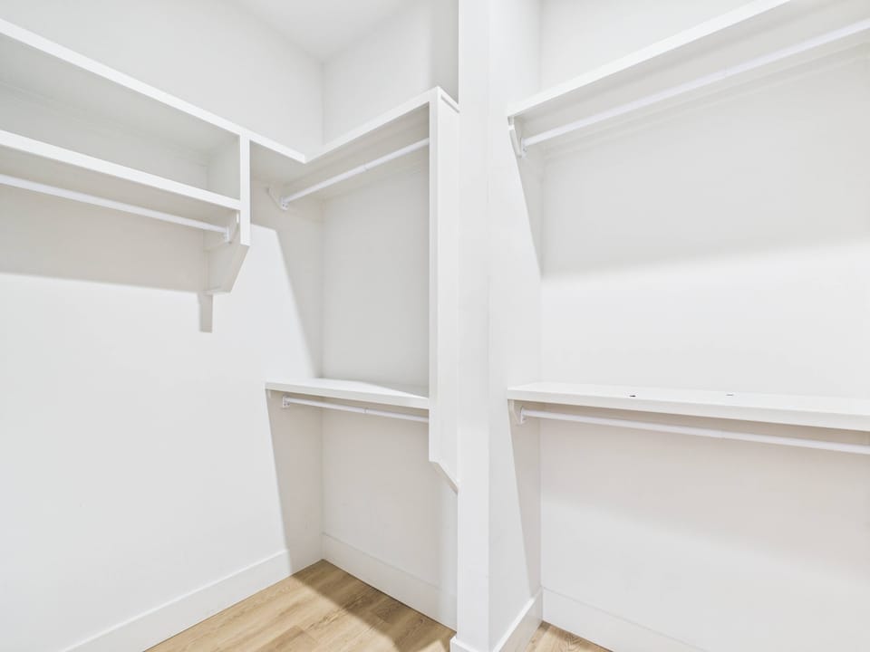Primary bathroom with a single vanity and a large walk-in closet.