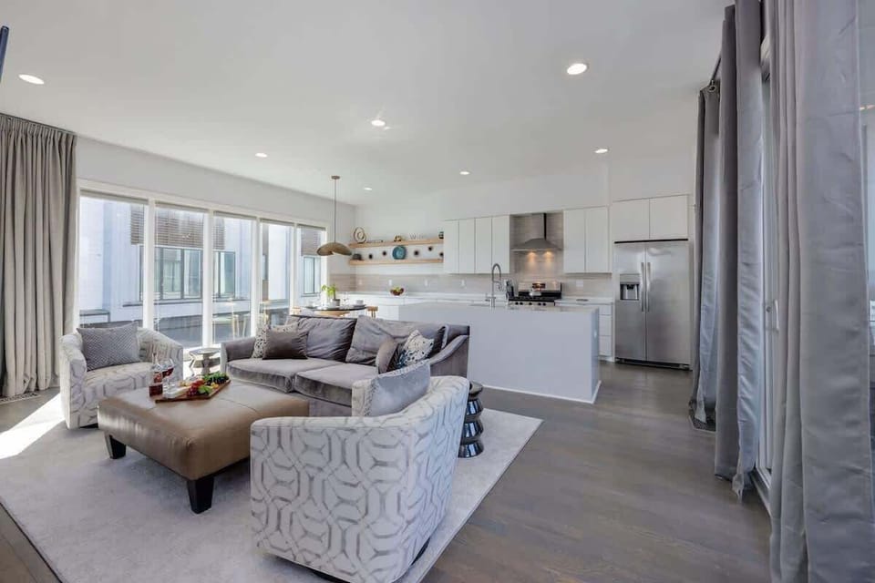 Bright open floor living space featuring designer furnishings, a smart TV, a fireplace, and access to a private balcony. (2nd Floor)