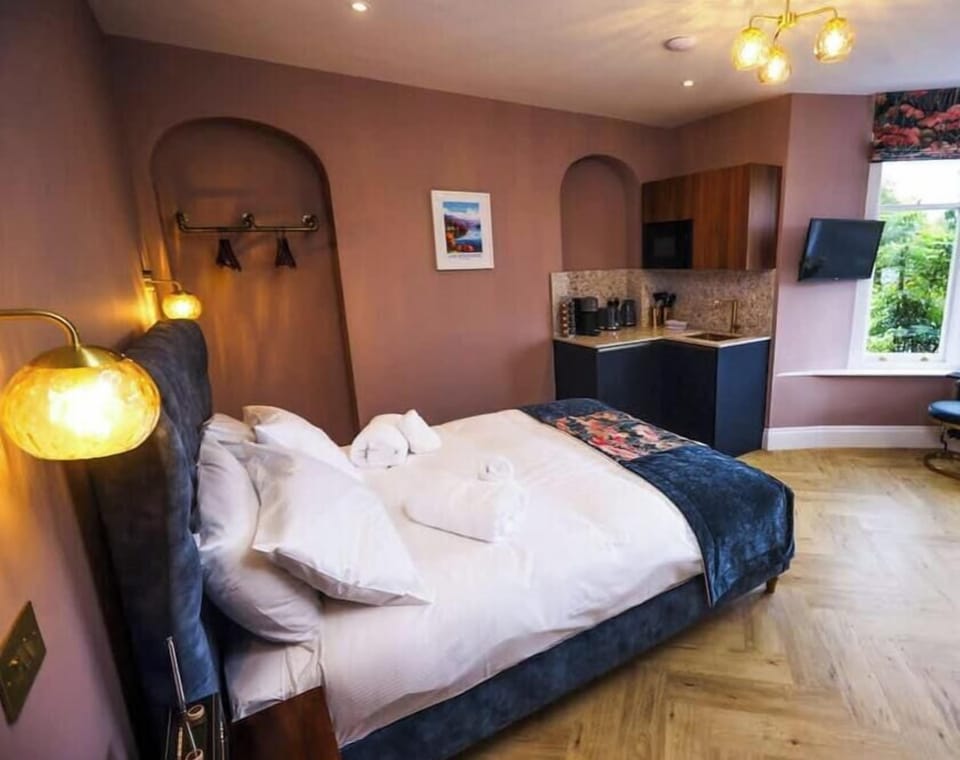 Experience opulence in our Ruskin studio at Fair Rigg by Cradel Haus, where a lavish bed and stunning bay windows create a luxurious retreat.