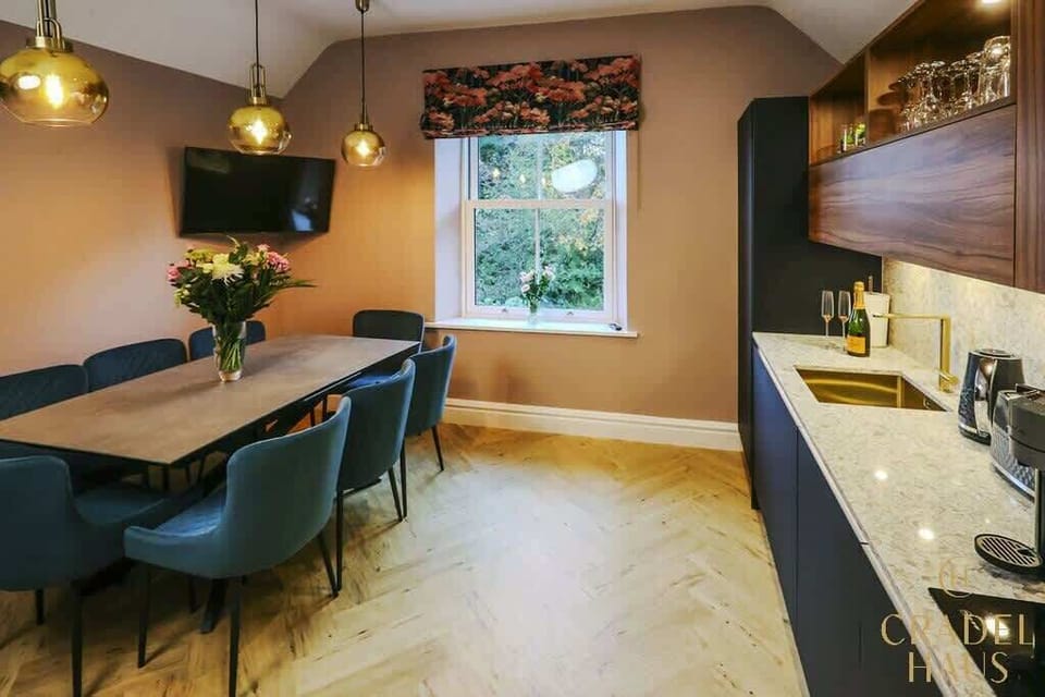 Experience the luxury of Windermere's kitchen diner, featuring premium granite countertops, brushed brass accessories, and a Smart TV for added enjoyment, providing a stylish and comfortable space to eat and unwind.