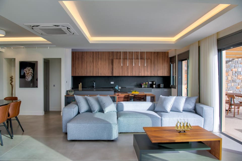 The living room features a comfortable sofa, a large 74-inch television equipped with Netflix, and direct access to the pool.