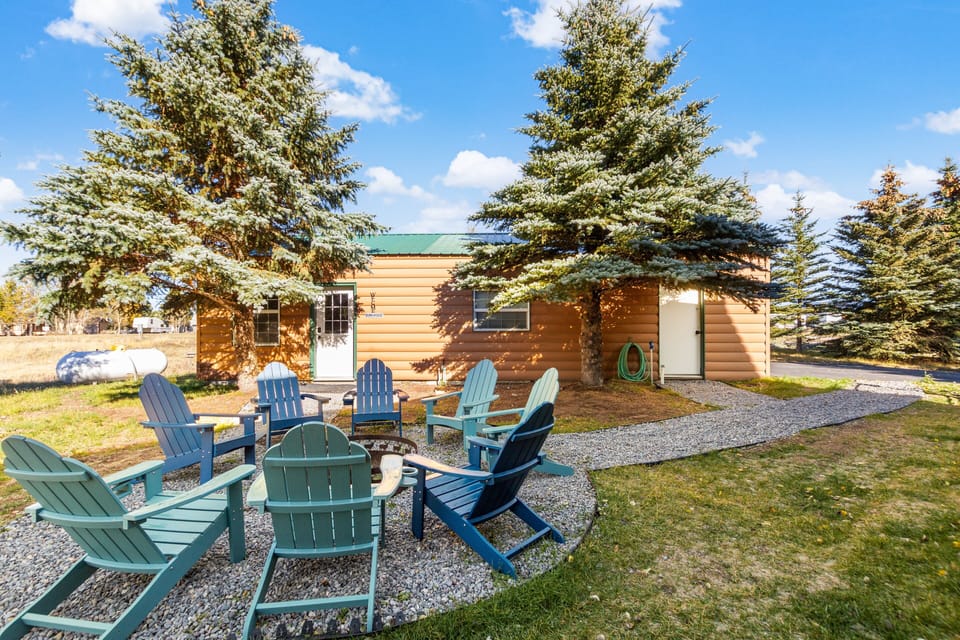 Step outside to your private fire pit gathering area, inviting long evenings under the stars. In the foreground, the private entrance to the detached bunkhouse offers added space and convenience