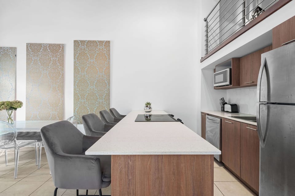 The kitchen features a full size fridge, microwave, coffee maker, 4-burner stove, and a dishwasher.