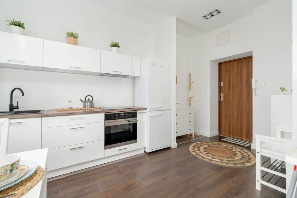 A well-organized kitchen with a wooden countertop, white cabinets, and thoughtful decor details.

