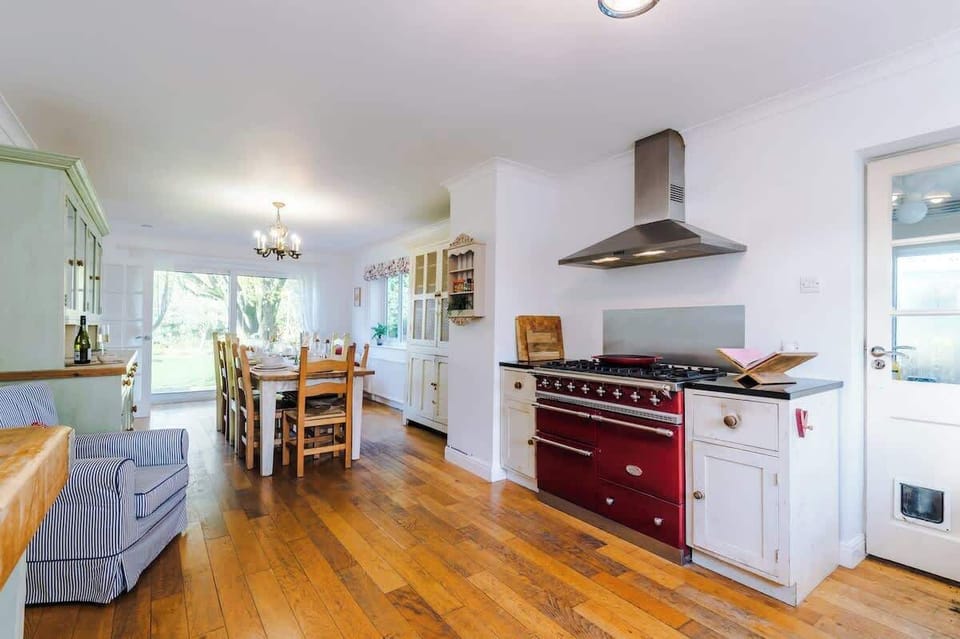 The heart of the home—a spacious country kitchen featuring a massive range cooker, Belfast sink, and a large dining table perfect for group feasts.