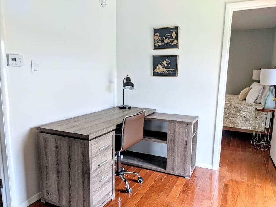The workspace features a large L-shaped desk and swiveling chair.