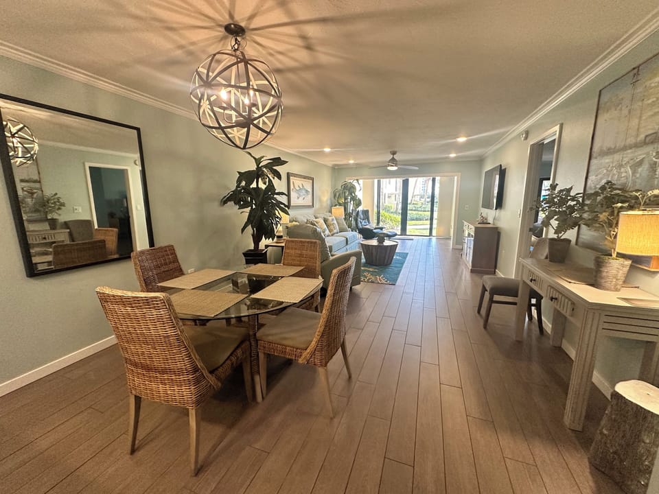 Your elegant open-plan living space combines dining and relaxation seamlessly, with warm wood floors and stylish lighting creating the perfect atmosphere.