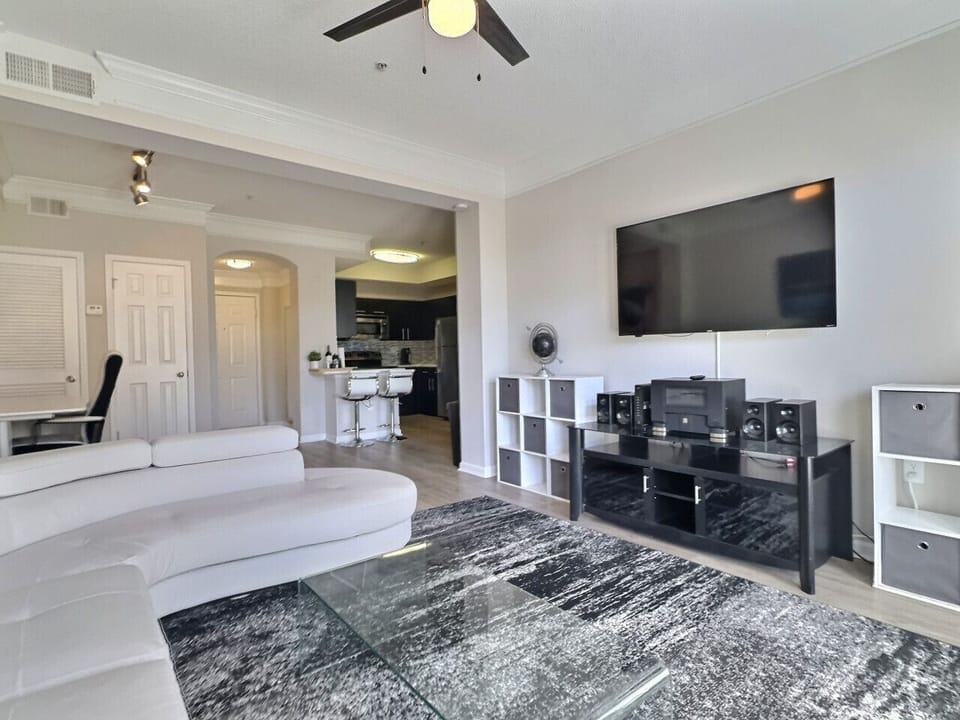The living area is equipped with a modern flat-screen TV and a sound system for your entertainment needs, perfect for a furnished apartment.