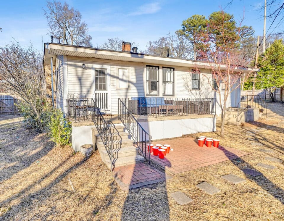 A versatile and roomy backyard in Downtown Birmingham, perfect for lively gatherings, featuring seating areas and entertainment options like cornhole to enjoy sunny days.