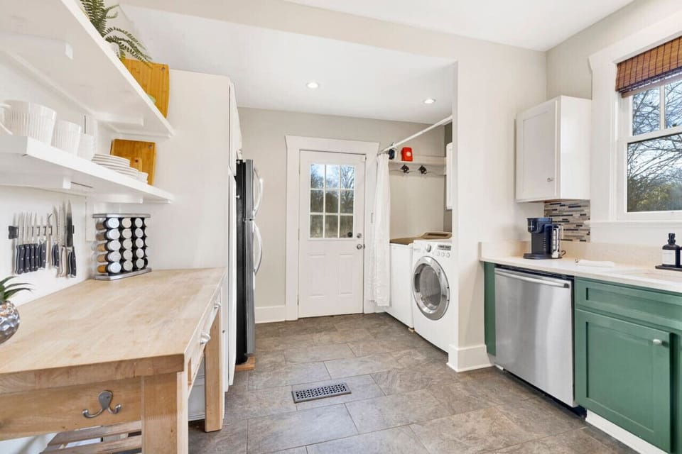 Modern kitchen with sleek stainless steel appliances and neatly arranged utensils, perfect for effortless cooking during your short-term rental stay.