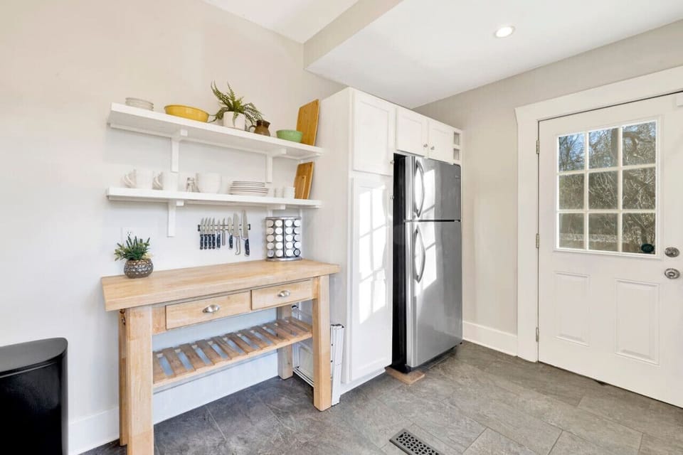 Modern kitchen with sleek stainless steel appliances and neatly arranged utensils, perfect for effortless cooking during your short-term rental stay.