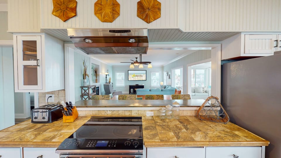 The creatively crafted opening above the cooktop range makes it easy for the cook to visit with others while preparing delicious meals in this state-of-the-art chef's kitchen.