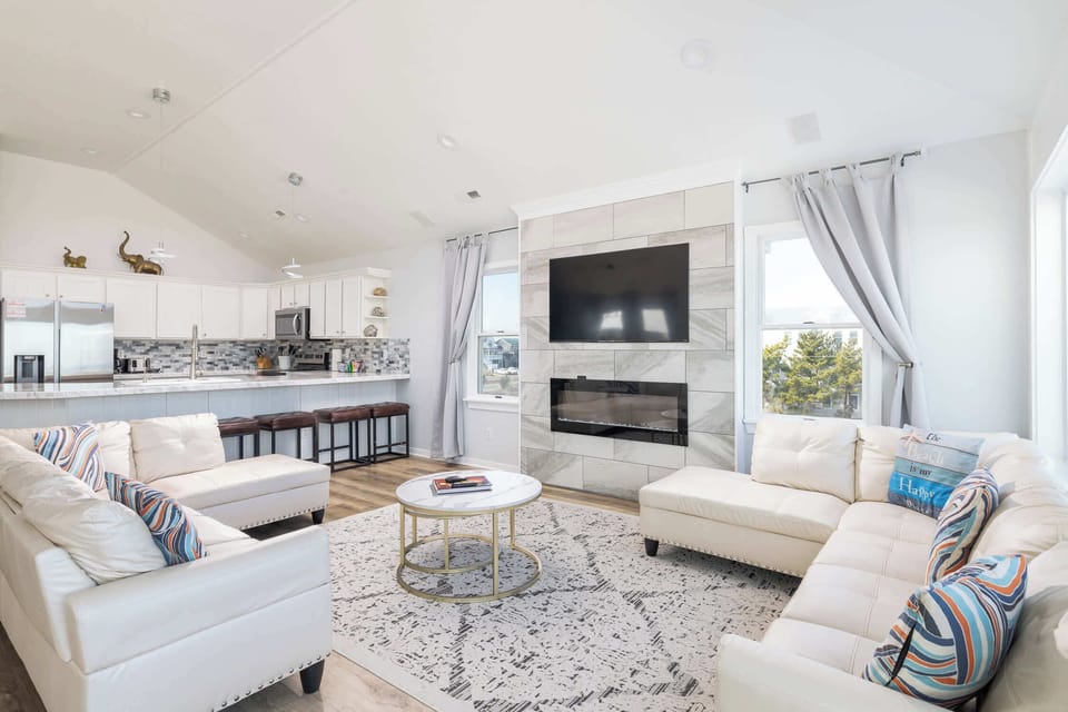Top Level: Spacious Living Area with Vaulted Ceilings, Cozy Sectional, Smart TV, and Large Windows with Beautiful Ocean Views