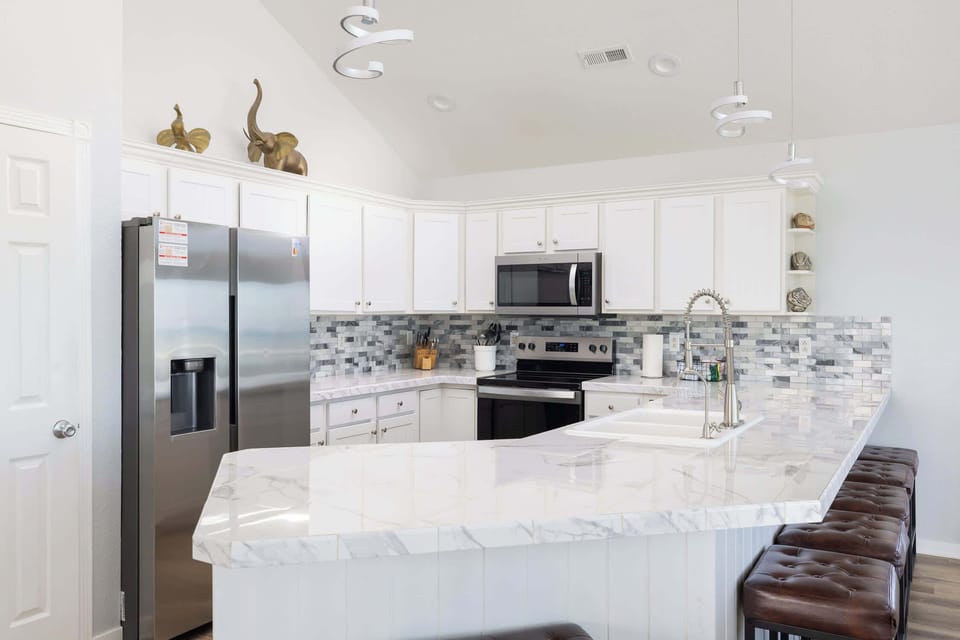 Top Level: Bright, Fully Stocked Kitchen with Breakfast Bar Seating