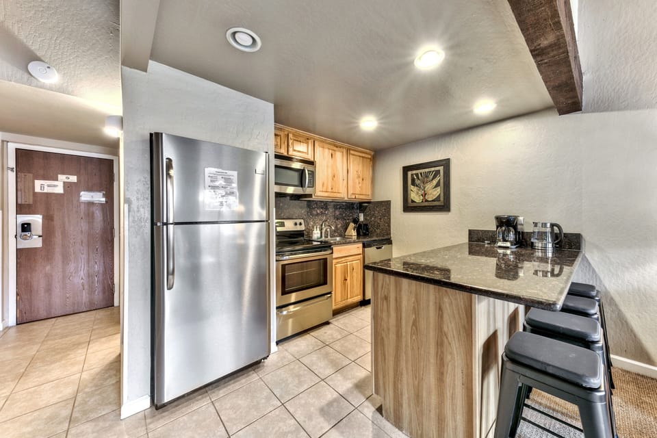 Your fully equipped kitchen features granite countertops, stainless steel appliances, and a breakfast bar perfect for morning coffee.