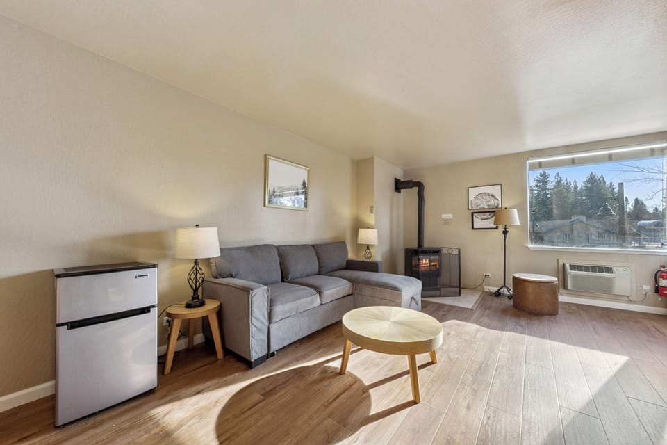 Relax in your cozy living space with plush sectional seating, warm fireplace, and mountain views through large windows.