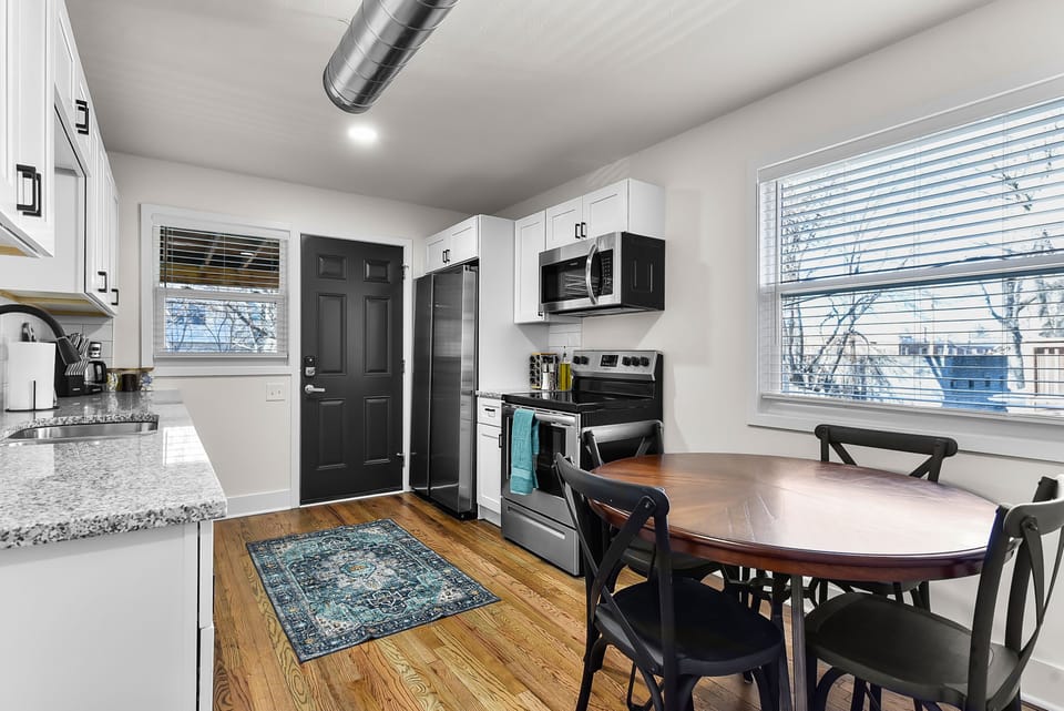 Your fully equipped kitchen and dining space features granite counters, stainless appliances, and warm wood floors perfect for home-cooked meals.