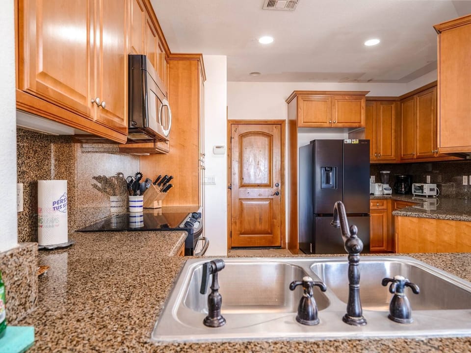 Fully equipped kitchen with refrigerator, oven, microwave, dishwasher, and coffee maker — everything needed for home-cooked meals.