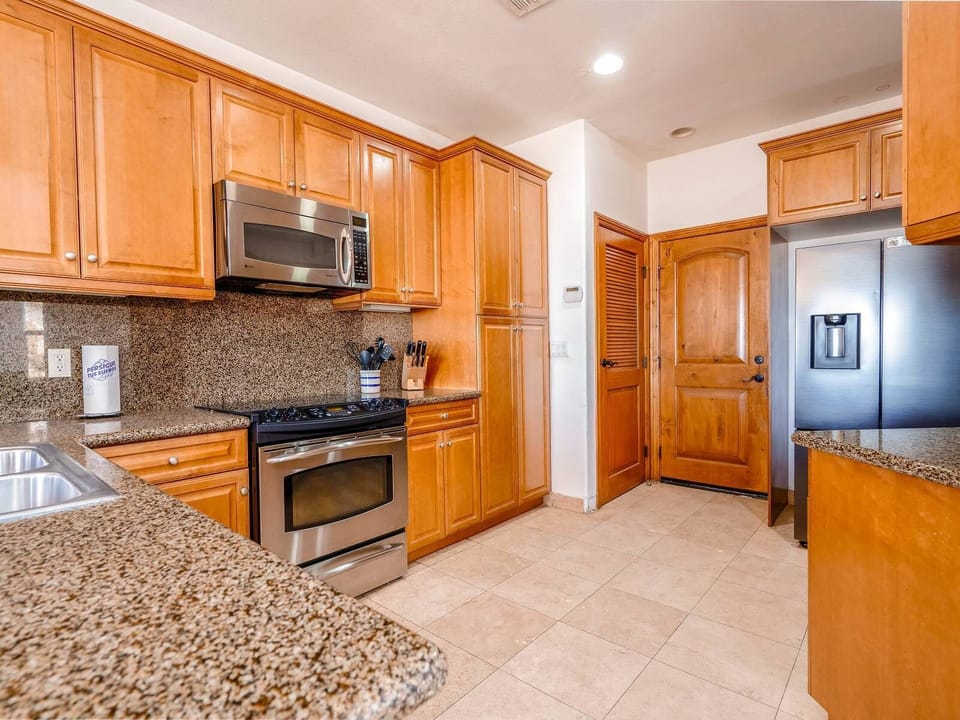 Fully equipped kitchen with refrigerator, oven, microwave, dishwasher, and coffee maker  — everything needed for home-cooked meals