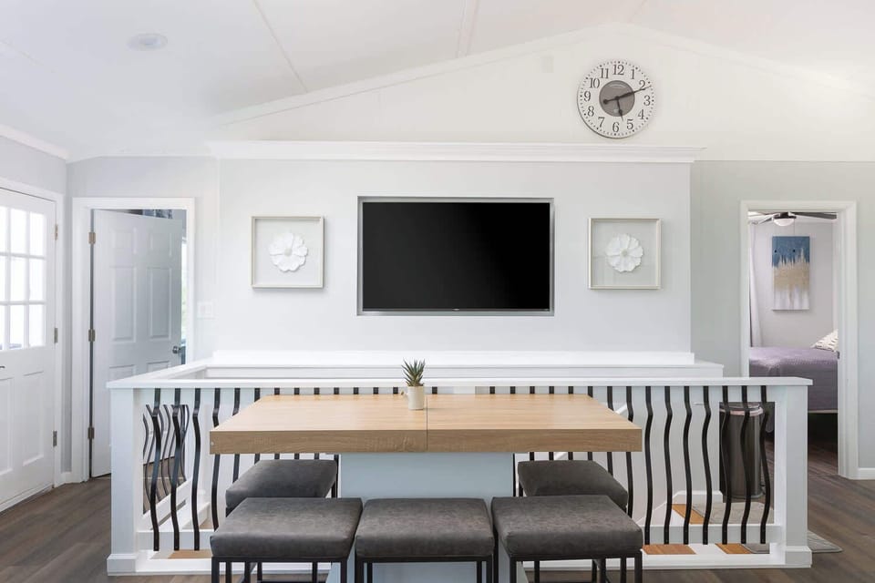 Top Level: Living space with TV and small table with chairs.