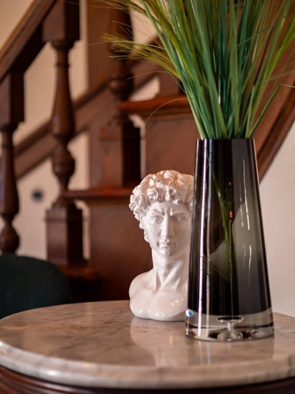 Decorative accent table styled w/ greenery & sculpture adding charm to the interior.