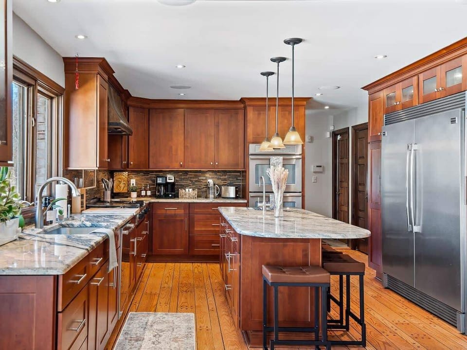 Spacious kitchen w/ island prep space, stainless appliances & warm wood cabinetry.