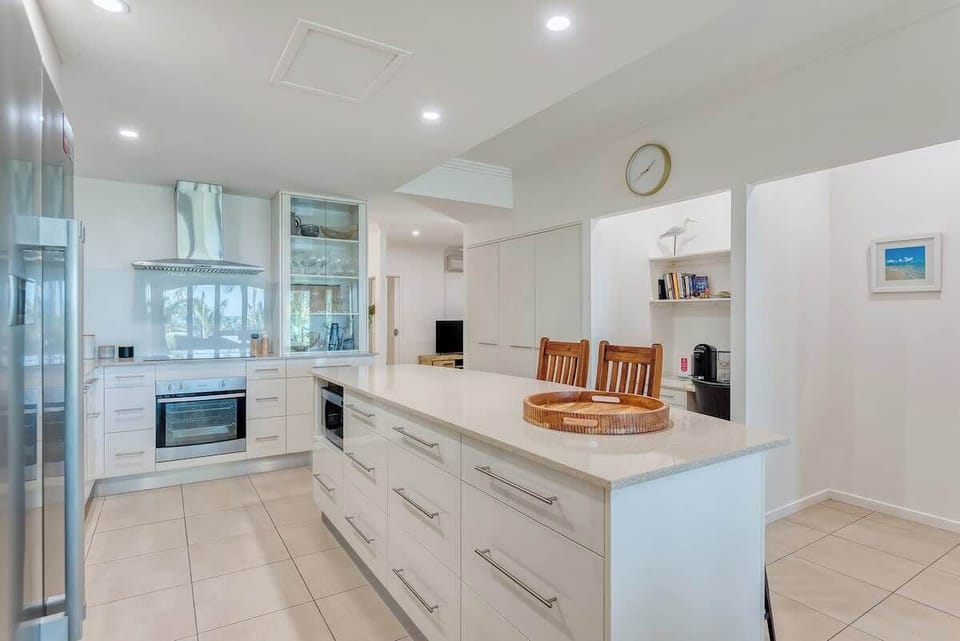 The kitchen highlights premium appliances and centres around an oversized island with seating to enjoy a quick bite to eat before hitting the beach.