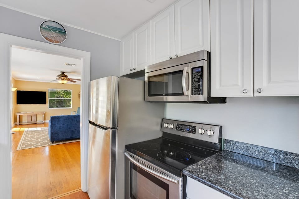 Fully equipped kitchen with modern appliances and basic cooking utensils.