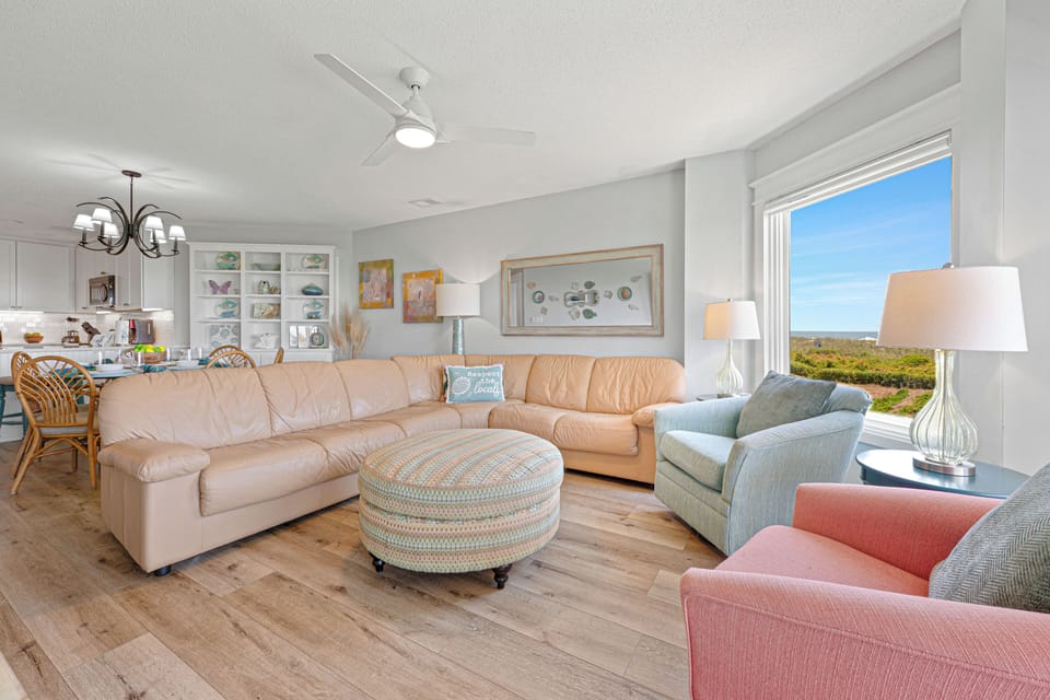 Comfortable seating, coastal-inspired décor, and abundant natural light create a welcoming space where family and friends can unwind.