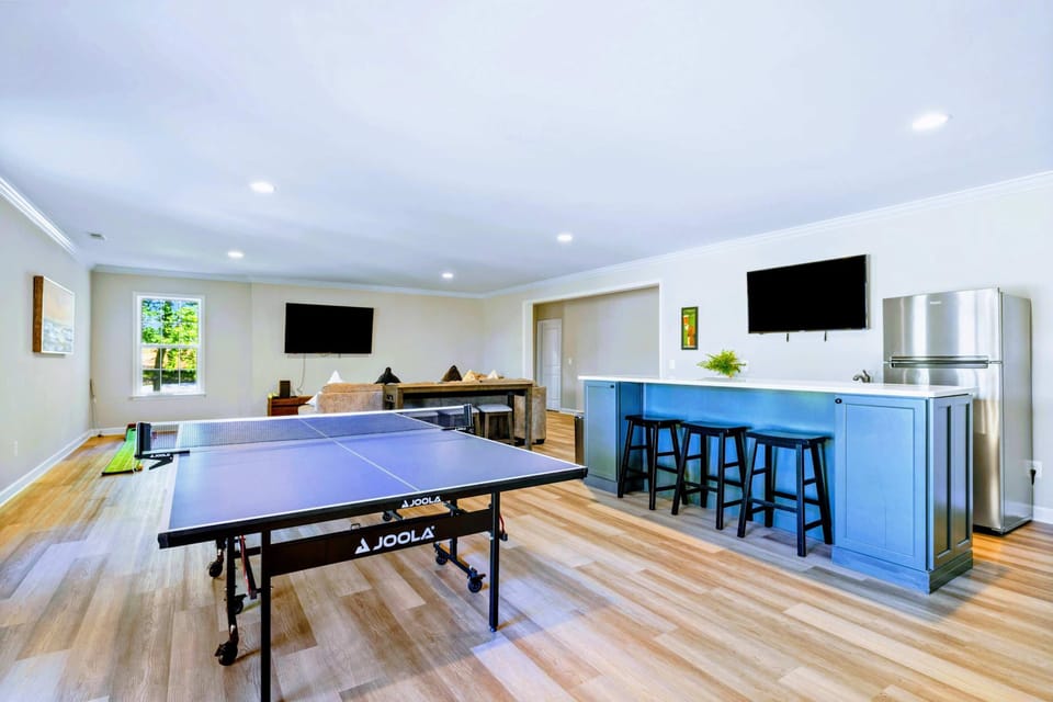 Game Room - Ping pong, a bar-height island with stools, and a wall-mounted TV: where the group goes after dinner.