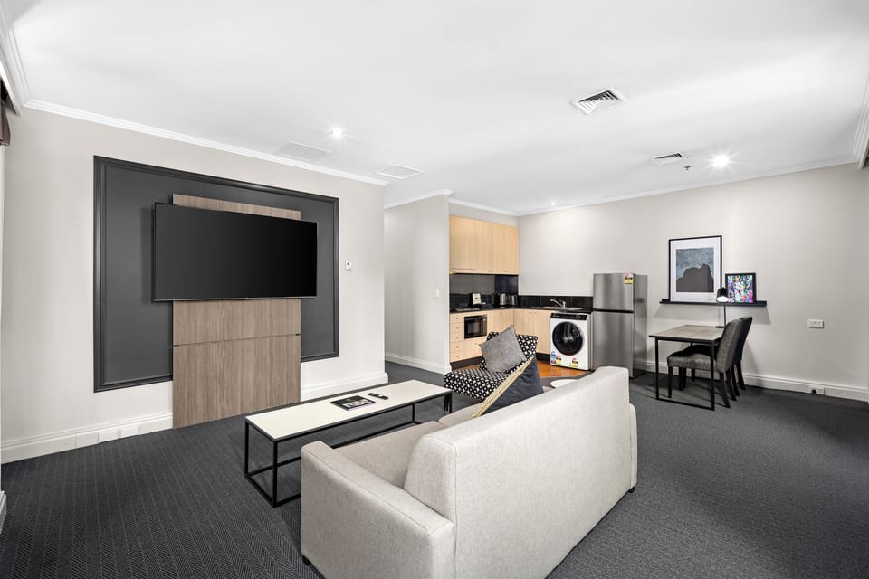 Signature One Bedroom Apartment | Living area | 65-inch LED TV with cable channels
