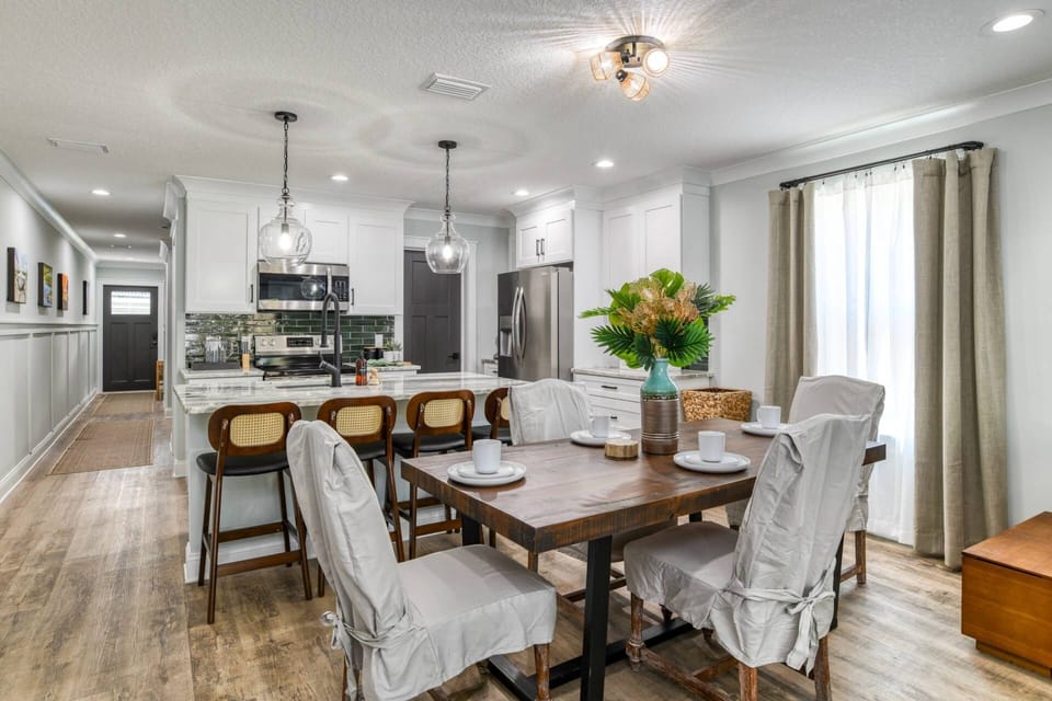 The dining table has plenty of space to share a meal together, including extra seating at the bar.