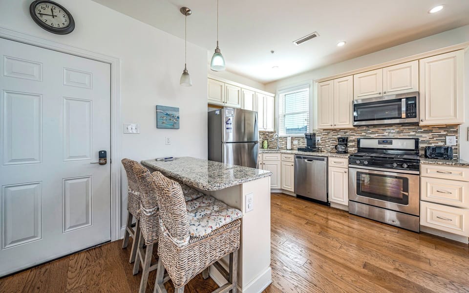 Coastal kitchen with 3-seat breakfast bar and stainless steel appliances