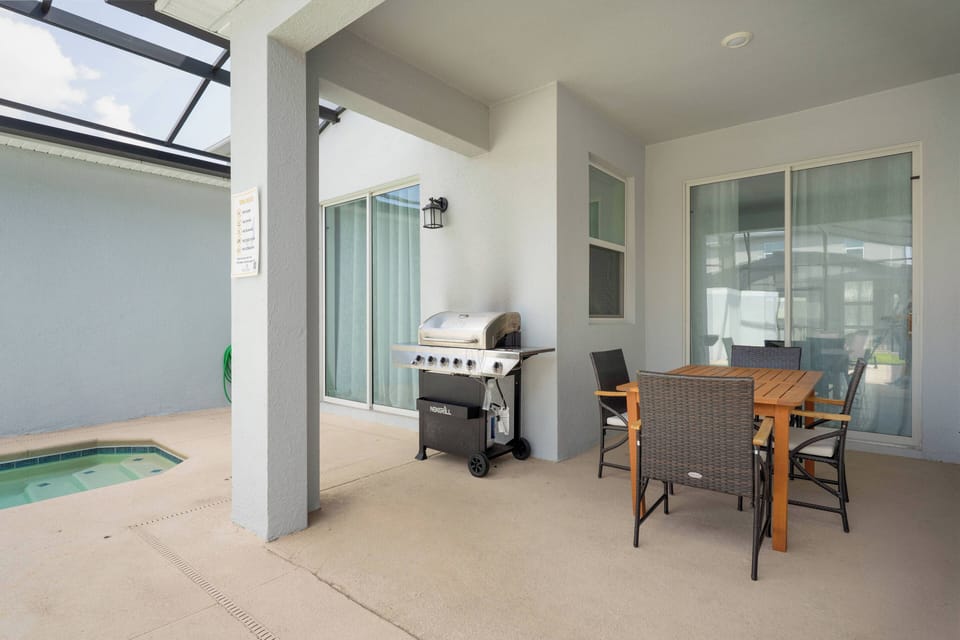Enjoy your private outdoor oasis with a sleek grill and stylish dining set, ideal for al fresco meals. The screened area lets you bask in the sunshine while staying protected, creating a cozy and inviting atmosphere.