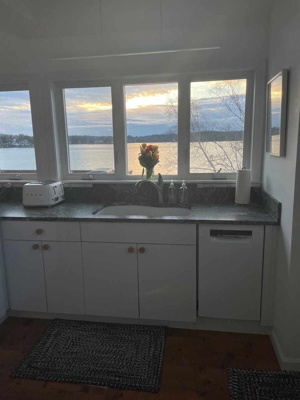 Kitchen overlooking the water with dishwasher. 