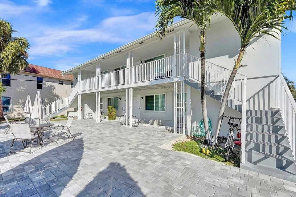 Tropical building exterior with palm trees and patio