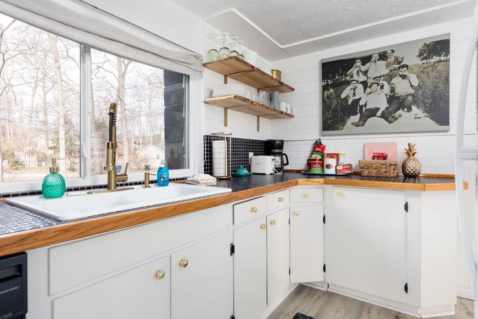 Bright kitchen corner w/ wraparound counters, open shelving & plenty of space to prep meals.