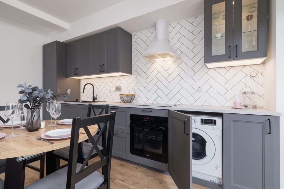 A sleek kitchen featuring dark gray cabinetry, a minimalist aesthetic, and state-of-the-art appliances, with a focus on functionality and style.