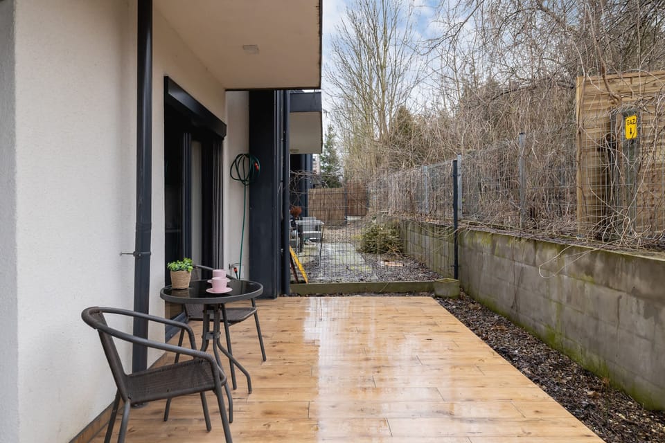 A private patio area with outdoor seating, surrounded by greenery, perfect for enjoying the fresh air in a peaceful setting.