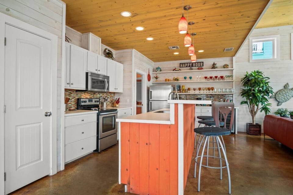 `Bright and open kitchen with charming island and beachy touches.`