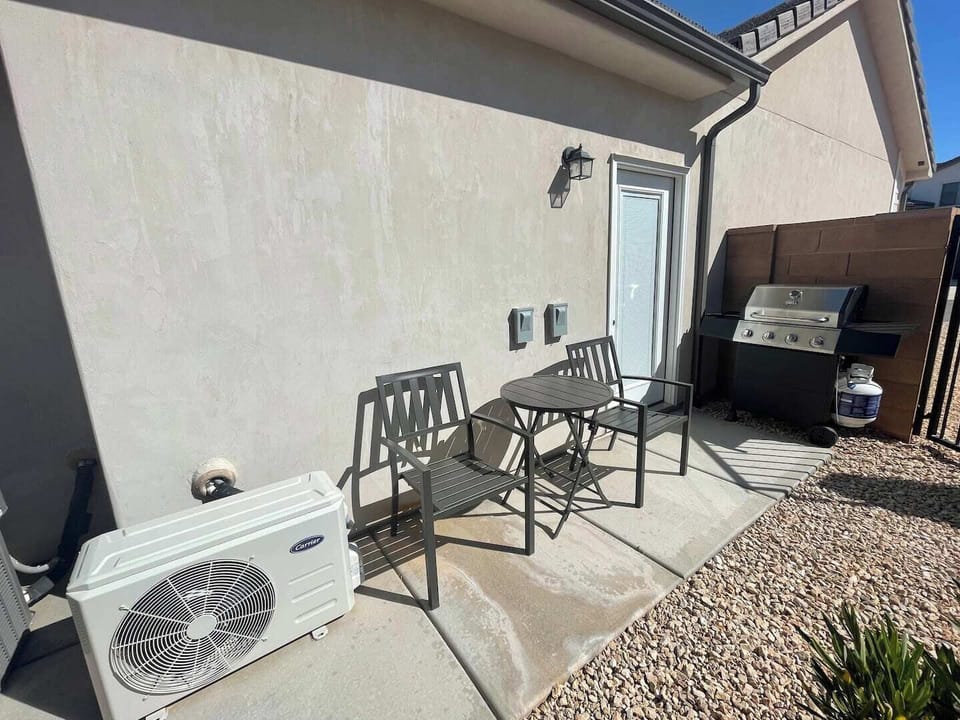 There is a small propane gas grill and a bistro table with 2 chairs for outdoor dining. 