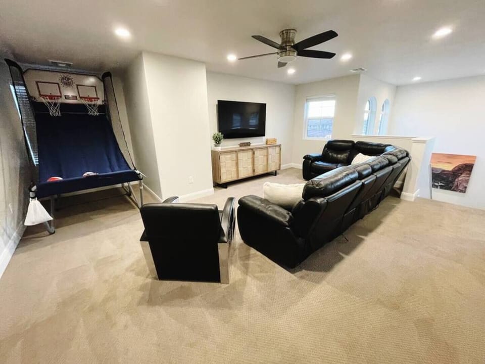 Upstairs second living area features a power reclining sectional, 65" Samsung smart TV, an Xbox with games, and pop-a-shot 