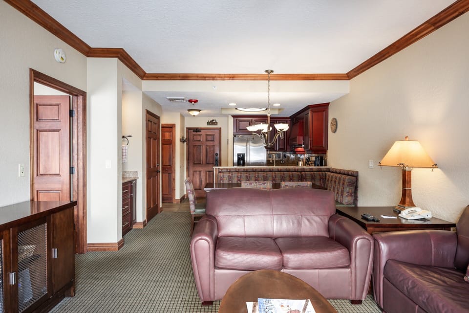 - Spacious living area with leather sofas and kitchen access nearby  
- Open layout flows naturally from entry to dining and fireplace  
- Comfortable retreat for relaxing after adventures on the slopes