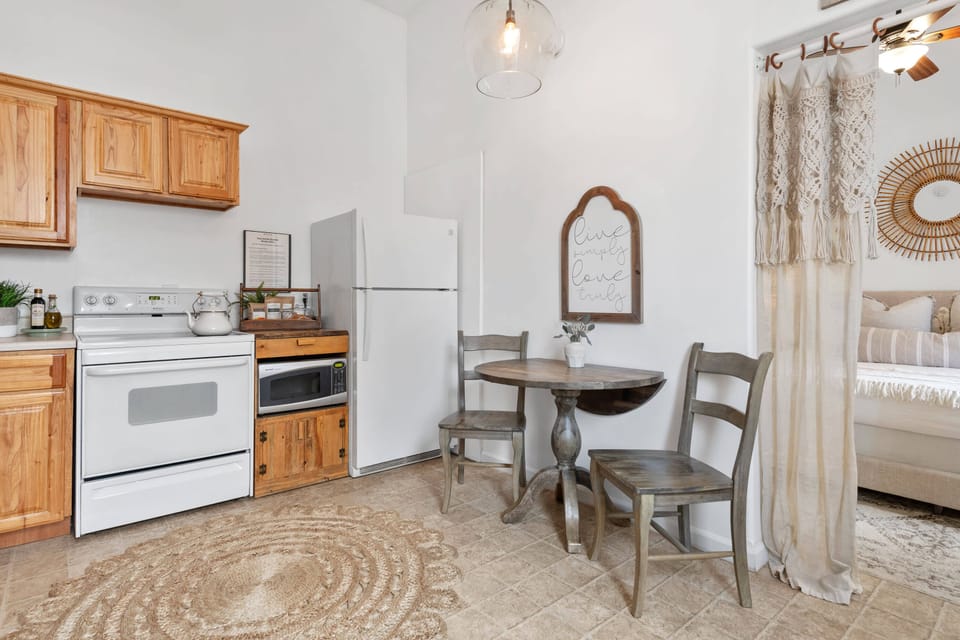 This space includes a full kitchen setup, a dining area, and a spacious bedroom.