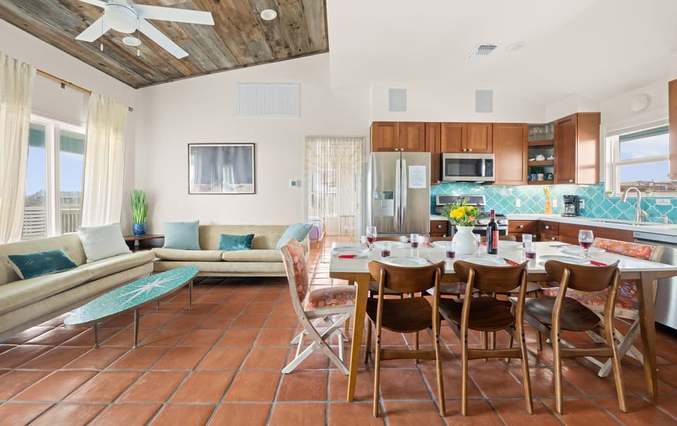 Open Floor Plan — Tan Sectional, Surfboard Coffee Table, Reclaimed Wood Ceiling, Kitchen & Dining