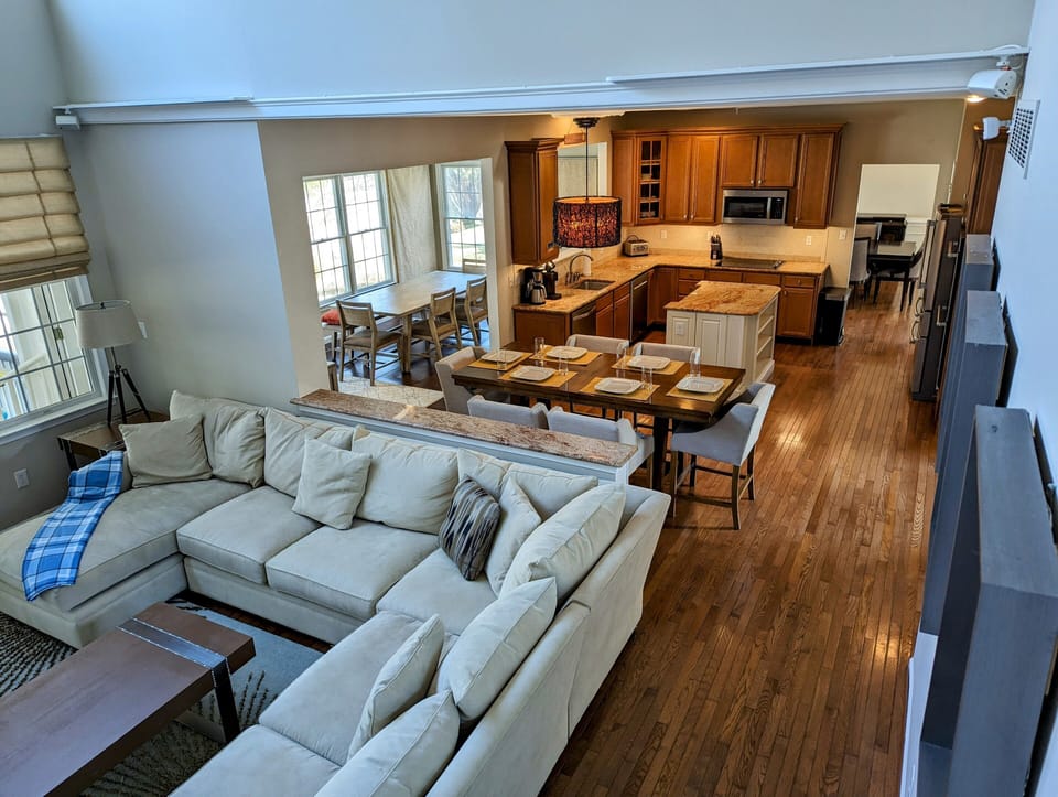 38353 Virginia Drive - Bethany Lakes - open concept living & din - This wide-angle view highlights the fluid layout between the living room, formal dining area, and the gourmet kitchen, featuring beautiful hardwood flooring throughout the main level.