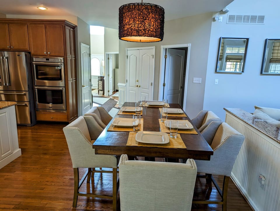 38353 Virginia Drive - Bethany Lakes - dining area - Dining space featuring a large wooden table with seating for eight, highlighted by a modern pendant light and a seamless flow into the open-concept living area.