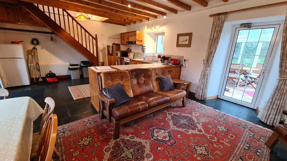Living room - with wood burning stove, TV and dining table.