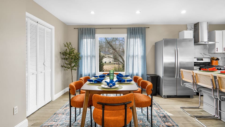 Dining area with 6 plush seats and window with sheer curtains