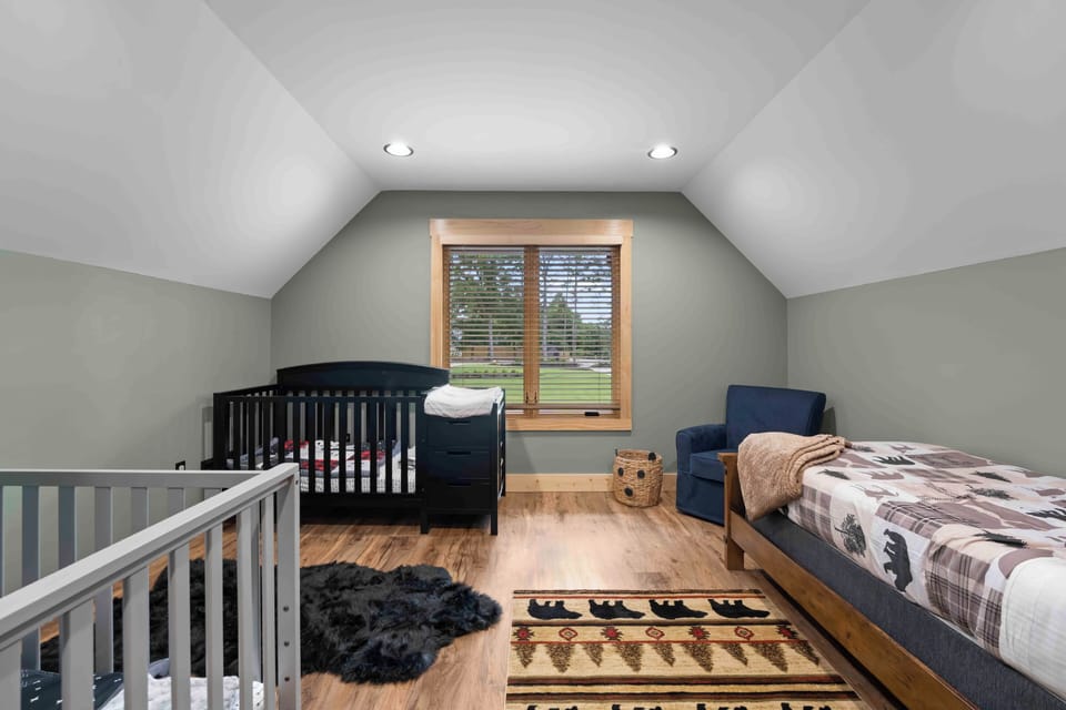 Nursery attached to the primary bedroom features a twin bed and two cribs.